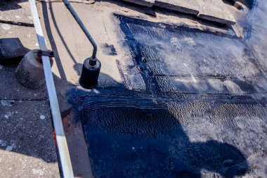 Isıtma ve alev tarafından bitüm yüzeyden Gaz Meşalesi erime ile çatı hissettim.