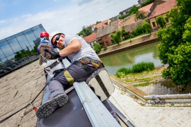 Görünüm üzerinde başarılı genç adam, başparmak yukarıya, ile iş yerinde endüstriyel dağcı yukarıda jest.