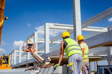 İşçi Vinç kanca kamyon römork gelen boşaltma beton kiriş için hazırlanıyor.