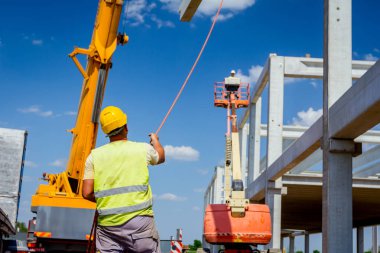 Çalışan mobil vinç halat boyu derleme büyük inşaat için beton kiriş yönetmek için yardımcı oluyor.