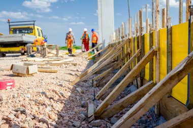 Uzun ahşap kalıp montajı ve yapı duvar temeli betonlama için hazır.