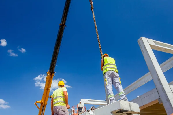 Pracownik Jest Przygotowanie Haka Dźwigu Dla Rozładunku Betonowych Belek Przyczepą — Zdjęcie stockowe