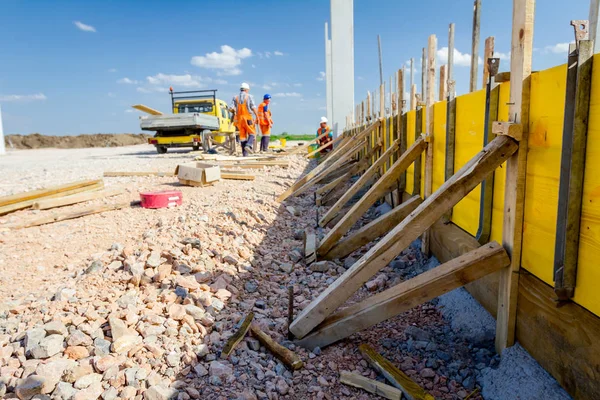 Uzun ahşap kalıp montajı ve yapı duvar temeli betonlama için hazır.