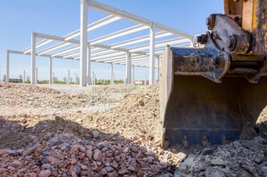 Ekskavatör'ın aracı, kova, bıçak, uzun boylu beton yapı 's değerindedir arkasında site oluşturma.