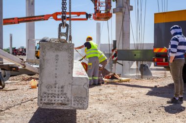Alt sağ uzunluğu için beton kiriş, asma kadar vinç üzerinde kurmak için zımpara taşlama makinesi kullanıyor.