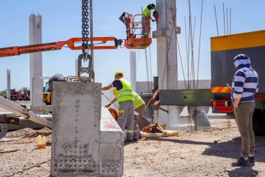Alt sağ uzunluğu için beton kiriş, asma kadar vinç üzerinde kurmak için zımpara taşlama makinesi kullanıyor.