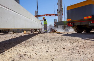 Alt sağ uzunluğu için beton kiriş, asma kadar vinç üzerinde kurmak için zımpara taşlama makinesi kullanıyor.