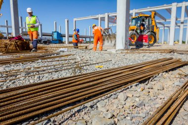 Arka planda yığılmış paslı güçlendirme çelik barlar beton, site oluşturma için görünümdür.