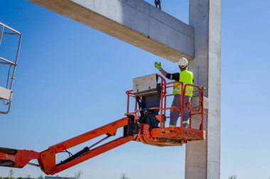 İşçi için derleme büyük inşaat beton kiriş yönetmek için Mobil vinç yardım ediyor.
