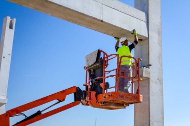 İşçi için derleme büyük inşaat beton kiriş yönetmek için Mobil vinç yardım ediyor.