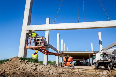 İşçi için derleme büyük inşaat beton kiriş yönetmek için Mobil vinç yardım ediyor.