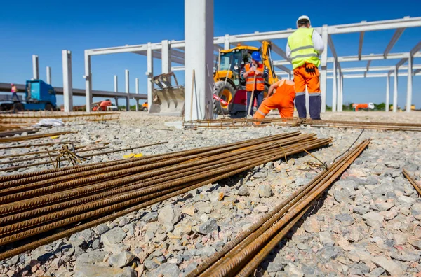 Arka planda yığılmış paslı güçlendirme çelik barlar beton, site oluşturma için görünümdür.