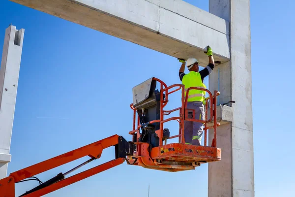 İşçi için derleme büyük inşaat beton kiriş yönetmek için Mobil vinç yardım ediyor.