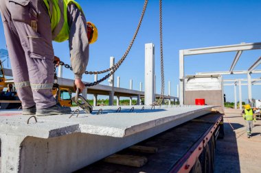 İşçi Vinç kanca kamyon römork gelen boşaltma beton kiriş için hazırlanıyor.