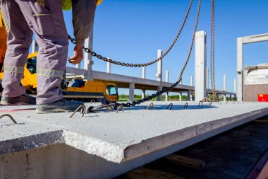 İşçi Vinç kanca kamyon römork gelen boşaltma beton kiriş için hazırlanıyor.