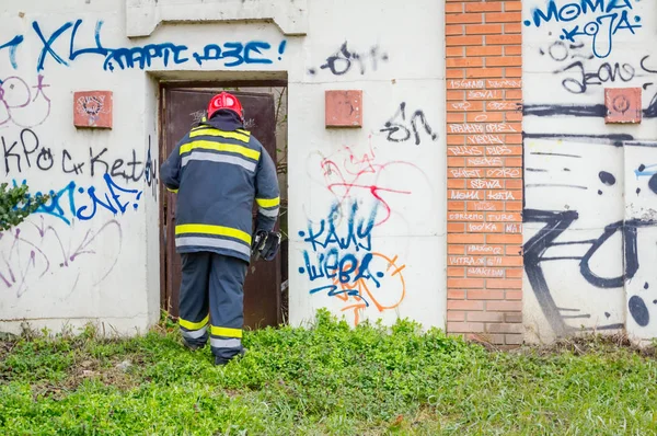 Bombeiro Está Passando Por Porta Metal Parede Tijolos Complexo Industrial — Fotografia de Stock