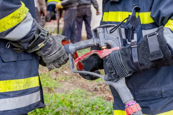 Пожарный Помогает Парню Собрать Водяной Пистолет Шланг — стоковое фото