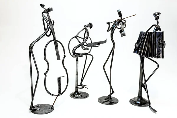 Figures of music performers made with welded black metal wire. Guitar, contrabass, accordion and violin are playing together. Living lines