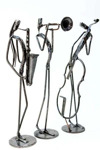 Figures of music performers made with welded black metal wire. Violoncellist, trumpeter and saxophonist are playing together. Living lines
