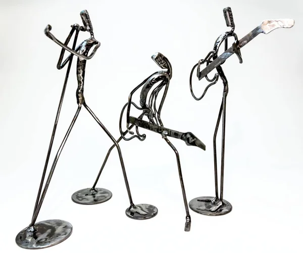 Figures of music performers made with welded black metal wire. Band made of guitarists and singer are playing together. Living lines