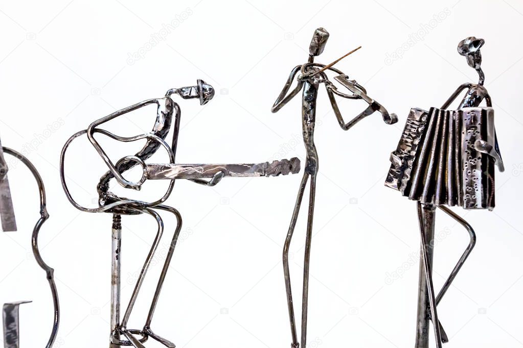 Figures of music performers made with welded black metal wire. Guitar, contrabass, accordion and violin are playing together. Living lines