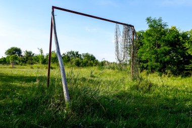 Çim bitki örtüsü arasında futbol ihmal edilen ve büyümüş mahkemede yalnız hedefi.