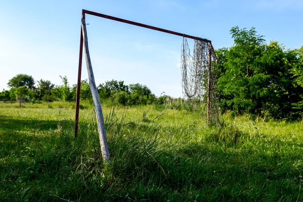 Çim bitki örtüsü arasında futbol ihmal edilen ve büyümüş mahkemede yalnız hedefi.