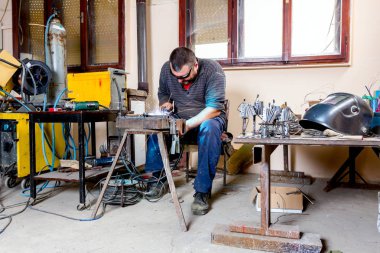 Heykeltıraş için derleme metal heykel ile koruyucu gözlük silâhsız ark kaynağı kullanıyor.