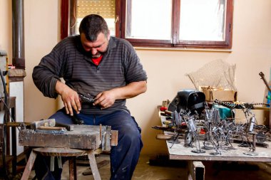 Sanatçı eğrisi tel doğru şekli onun elinde özel araçları ile metal işleme. 