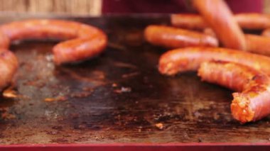 Lezzetli sulu sosis çelik Barbekü plaka saplı açma. Metal maşa yardımıyla cızırtılı sosis metal plaka, mangal dönüyor. 