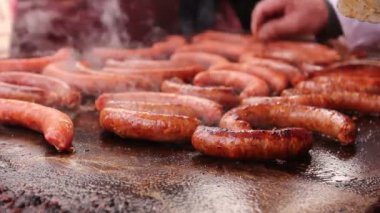 El ahşap kürdan ile siyah Barbekü ızgara sosis kaynayan küçük delikler yapıyor. 