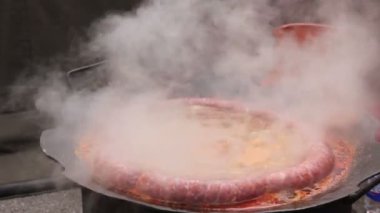 Barbekü plaka üzerinde lezzetli sulu sosis pişirme. Geleneksel ev yapımı domuz sosisi Barbekü Izgara, metal zor durumda kaynayan.