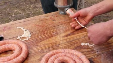 Kasap domuz bağırsak sosis yapmak için kıyma ile doldurma. Sosis için el yapımı sosis makinesi ile yapmak için domuz bağırsağı doldurmak.