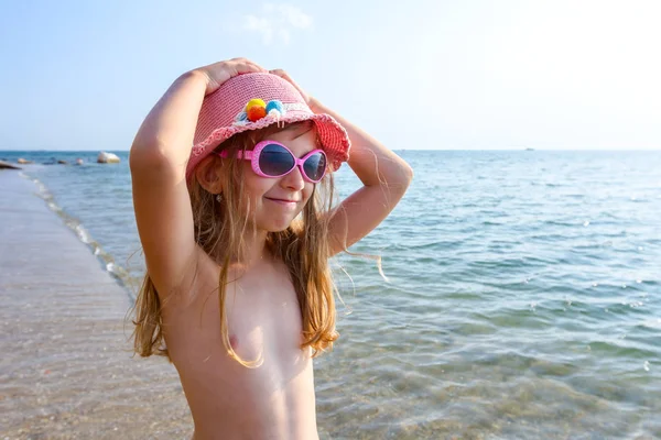 Genç kadın portresi, deniz kıyısında yaz şapka ve güneş gözlüğü keyif alıyor.