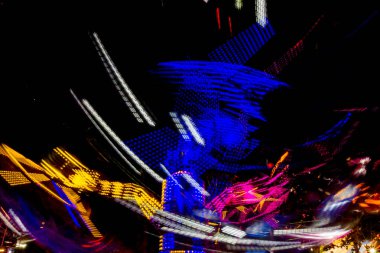 Uzun pozlama canlı aydınlatmalar ile gece ışıklı bir hızlı dönen renkli atlıkarınca, lunapark sürmek Luna parkta.