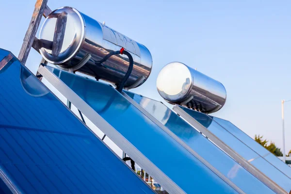 再生可能エネルギーを利用するための水パネルは 家の屋根 太陽熱温水システムに配置されています 現代の省エネ技術 — ストック写真