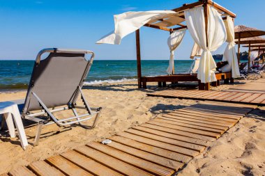 Ahşap yolu, kumsalı ile beyaz perde güneşli Plajı ile konforlu ahşap pergola için gidiyor.