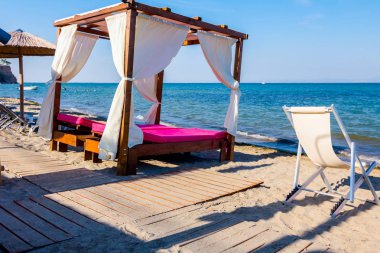 Ahşap yolu, kumsalı ile beyaz perde güneşli Plajı ile konforlu ahşap pergola için gidiyor.