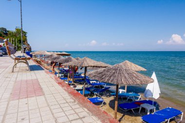 Geçit arkasında, Halk Plajı üzerinde şemsiye, şemsiye ve şezlonglar insanlar, kıyı şeridi yanındaki yer turist ile thatched.