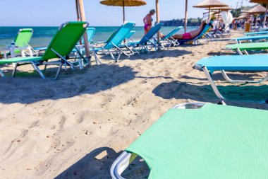 Boş Halk Plajı ile thatched şemsiye, şemsiye ve şezlonglar için mükemmel bir tatil görüntüleyin.