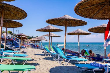 Boş Halk Plajı ile thatched şemsiye, şemsiye ve şezlonglar için mükemmel bir tatil görüntüleyin.