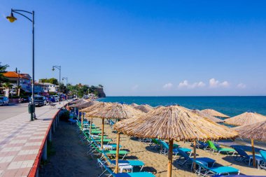 Geçit arkasında, Halk Plajı üzerinde şemsiye, şemsiye ve şezlonglar insanlar, kıyı şeridi yanındaki yer turist ile thatched.
