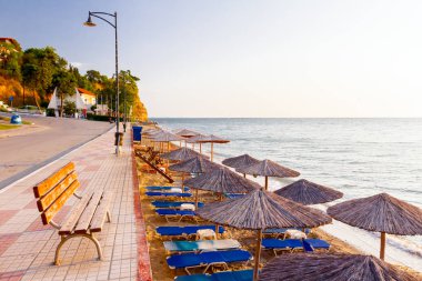 Ahşap Bank döşeli Patika arkasında, ama halk plajı ile thatched şemsiye, şemsiye ve şezlonglar kıyı şeridi yanındaki yukarıda yerleştirilir.