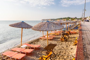 Geçit arkasında, boş Halk Plajı ile thatched şemsiye ve şezlonglar erken sabah güneş üzerindedir.