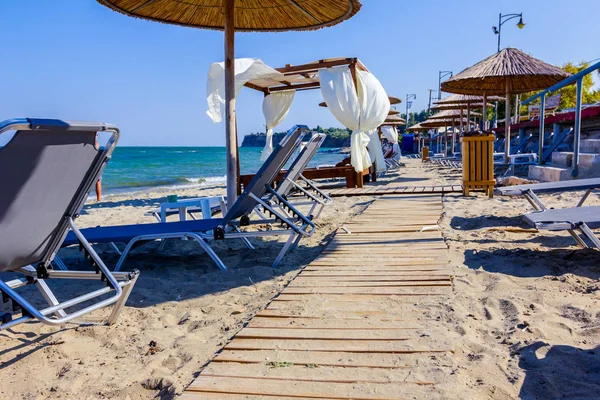 Ahşap yolu, kumlu boş Halk Plajı, şemsiye ve şezlonglar için mükemmel bir tatil geçiyor.