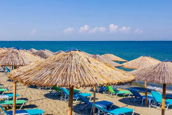 在公共海滩上可以欣赏到遮阳伞 遮阳伞和塑料躺椅的美景 度过一个完美的假期 — 图库照片