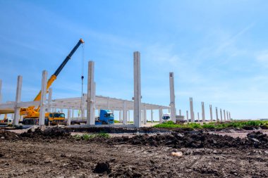 Vinçler-Mobil vinç montaj endüstriyel bina büyük beton iskelet var. Manzara dönüşümü makine ile kentsel alan kişi çalışıyor. Şantiye görüntülemek.