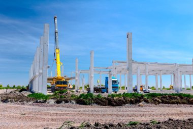 Vinçler-Mobil vinç montaj endüstriyel bina büyük beton iskelet var. Manzara dönüşümü makine ile kentsel alan kişi çalışıyor. Şantiye görüntülemek.