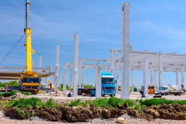 Vinçler-Mobil vinç montaj endüstriyel bina büyük beton iskelet var. Manzara dönüşümü makine ile kentsel alan kişi çalışıyor. Şantiye görüntülemek.