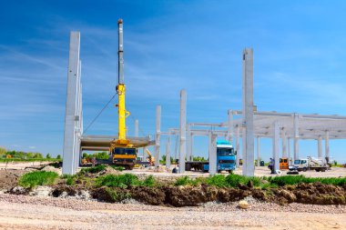 Vinçler-Mobil vinç montaj endüstriyel bina büyük beton iskelet var. Manzara dönüşümü makine ile kentsel alan kişi çalışıyor. Şantiye görüntülemek.
